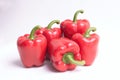 Close-up of a group of short square or California red peppers with flash lighting and neutral background