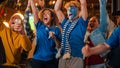 Close Up on a Group of Supportive Soccer Fans with Painted Blue and White Faces Standing in a Bar Royalty Free Stock Photo