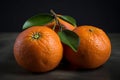 Close Up of Group of Three Oranges With Green Leaves on Table Dark Background