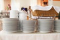 Close-up of a group of white ceramic tea cups and plates standing on a table with a white tablecloth, clean dishes in the hotel Royalty Free Stock Photo