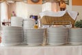 Close-up of a group of white ceramic tea cups and plates standing on a table with a white tablecloth, clean dishes in the hotel Royalty Free Stock Photo