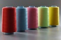 Group of whole haberdashery item colorful thread spools on grey surface