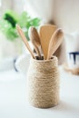 A close-up of a group of wooden kitchen utensils inside a glass container with a string of whipping. Eco style. Cooking with