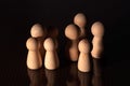 Close up of a group of wooden pawns on a dark background.