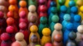 A close up of a group of wooden people toys in different colors, AI