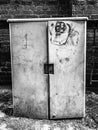 A grungy service utility box with graffiti