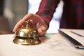 Close Up Of Guest's Hand On Hotel Reception Bell Royalty Free Stock Photo