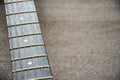 Close-up guitar fretboard with strings isolated on a blurred gray background with copy space. Music concept. Guitar neck texture. Royalty Free Stock Photo