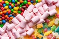 Close-up of gummies, colored chocolate balls and marshmallows placed in three diagonal lines occupying the entire horizontal image