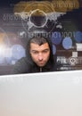 Close up of hacker using a laptop behind a digital screen Royalty Free Stock Photo