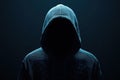 Close-up of a hacker wearing black hood on dark background. Royalty Free Stock Photo
