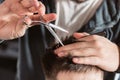 Close-up Hair cutting with metal scissors. Master cuts hair and beard of men in the barbershop, hairdresser makes