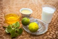 Close up of hair mask for the treatment of aggravated scalp on brown colored surface i.e. yogurt,,honey and lemon juice in a glass