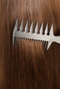 Close up of haircare, comb moves along beautiful healthy long flowing brown hair, texture. Healthy long smooth flowing