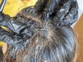 Close-up of a hairdresser in black gloves massaging a woman`s hair after dyeing