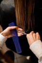 Close-up of hairdresser hand during cutting female hair at beauty salon Royalty Free Stock Photo