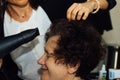 Close up of hairdresser hands drying human hair with equipment. Woman holding a comb Royalty Free Stock Photo