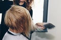 Close up of hairdresser hands drying human hair with equipment. Woman holding a comb. close-up. Macro photo Royalty Free Stock Photo