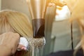 Close up of hairdresser hands drying human hair with equipment. Woman holding a comb. close-up. Macro photo Royalty Free Stock Photo