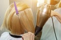 Close up of hairdresser hands drying human hair with equipment. Woman holding a comb. close-up. Macro photo Royalty Free Stock Photo