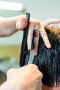 Close up of hairstylist`s hands cutting strand of man`s hair. Professional hairdresser or barber occupation. Royalty Free Stock Photo