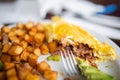 Half-eaten omelette and roasted potatoes on a white plate