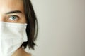 Close up of half the face of caucasian woman wearing a white face mask for protection during Covid-19 Royalty Free Stock Photo