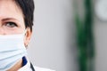 Close up half face portrait of Senior Family Medical Doctor in Face Mask. Successful Physician in White Lab Coat Looks Royalty Free Stock Photo