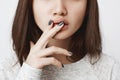 Close-up half face portrait of young european female, biting anxiously lips and holding fingers on them. Parents still Royalty Free Stock Photo