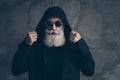 Close-up half-faced portrait of nice attractive focused bearded gray-haired man wearing putting on modern look hood Royalty Free Stock Photo