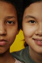 Close-up of half faces of two youthful multicultural girls