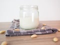 Close up of a half glass of almond milk on grey towel with almonds