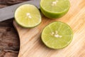 a half of the green lime and seed with a knife place on wooden board Royalty Free Stock Photo