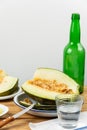 Close up of half green melon with knife on wooden table with green bottle Royalty Free Stock Photo