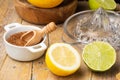 Close-up of half lemon, lime, brown sugar, juicer and wooden bowl with lemons, black background, Royalty Free Stock Photo