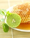 Close up half a lemon with sweet honeycombs and mint leaf Royalty Free Stock Photo