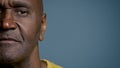 Close-up half male face mature african american man looking camera middle-aged client patient posing in studio gray Royalty Free Stock Photo