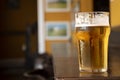 close up half pint of pale lager pilsen beer with blurred background on pub counter