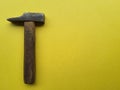 Close-up of hammer, antique with wooden handle, isolated against yellow background. Royalty Free Stock Photo