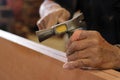 Close up hammer and nail using by carpenter on wooden board. Selective focus and shallow depth of field. Royalty Free Stock Photo