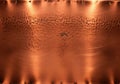 Close up of hammered copper texture with warm light reflections Royalty Free Stock Photo