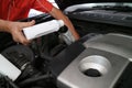 Close up hand adding fresh oil into engine car, repairing change the oil. Car maintenance at service station.