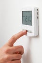 Close Up Of hand Adjusting Digital Central Heating Thermostat Royalty Free Stock Photo
