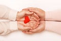 Close-up of the hand of an adult daughter and an older mother holding a heart together. Top view. Family and care concept Royalty Free Stock Photo