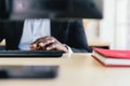 Close Up hand of the African businessman typing keyboard with a red notebook on his desk workplace with copy space Royalty Free Stock Photo