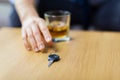 Close up of hand with alcohol and car key on table Royalty Free Stock Photo