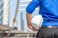 Close up hand architect worker holding white helmet a for workers security control at city site. Engineer inspector construction b Royalty Free Stock Photo