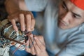 Close up of the hand of an asian electronics repairman connecting the broken fan cable