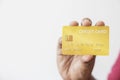 Close-up hand of Asian man holding yellow gold credit card in his hand. isolated on white background. Concept of finance, trading Royalty Free Stock Photo