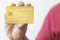 Close-up hand of Asian man holding yellow gold credit card in his hand. isolated on white background. Concept of finance, trading Royalty Free Stock Photo